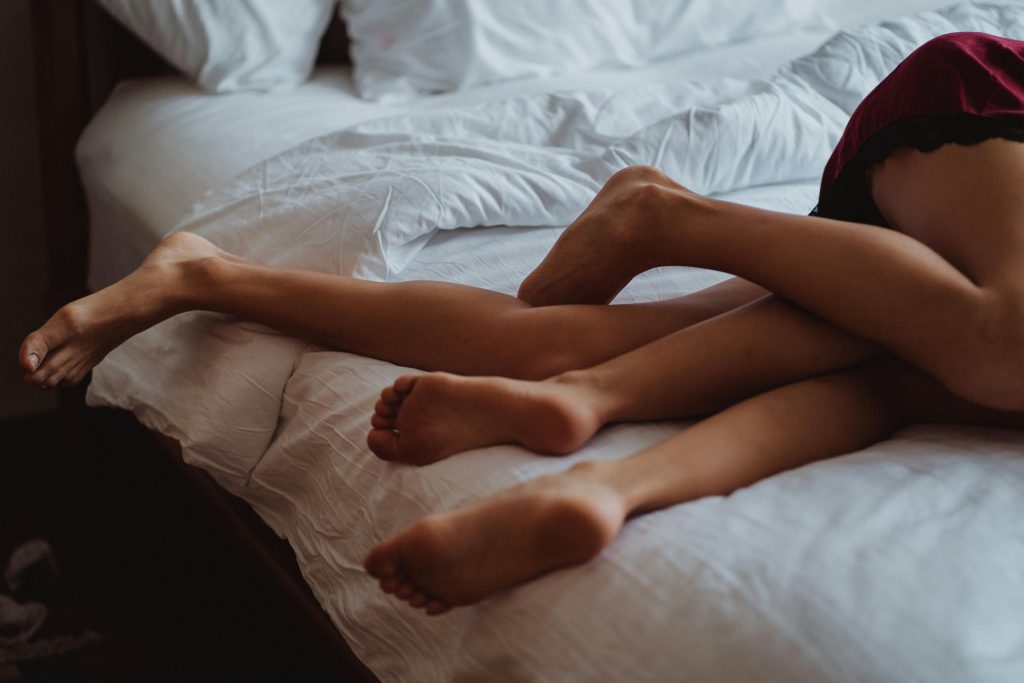 pexels-photo-4759930-4759930 A close-up of intertwined legs illustrating intimacy and relaxation on a bed.