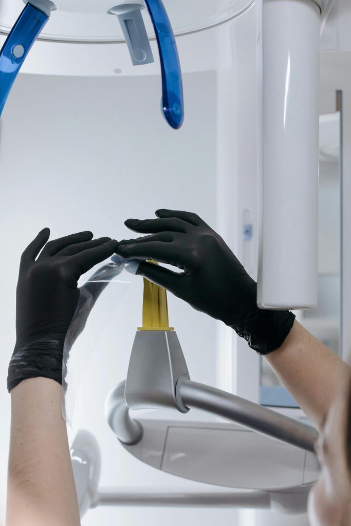 pexels-photo-6501851-6501851 Focused view of hands in black gloves setting up dental equipment in a clinic environment.
